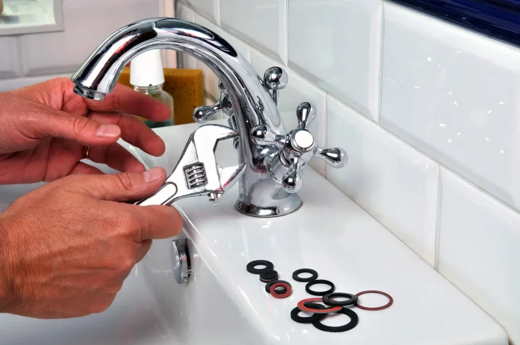 Plumber performing maintenance on a bathroom faucet in Fort Collins