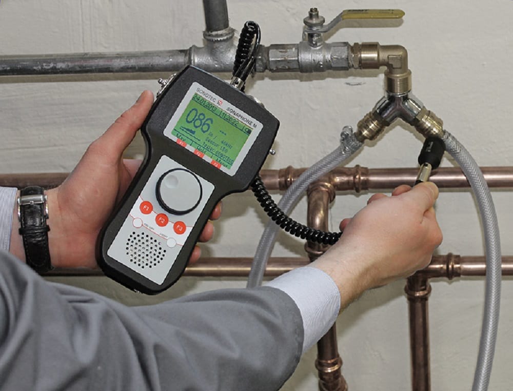 Plumber testing pipes with electronic leak detection equipment in Fort Collins