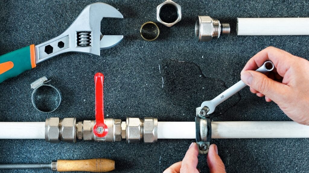 Plumbing tools and pipe fittings used for valve installation in Fort Collins
