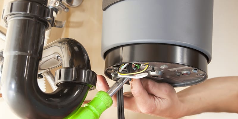 Technician repairing the heating element of a water heater in Fort Collins
