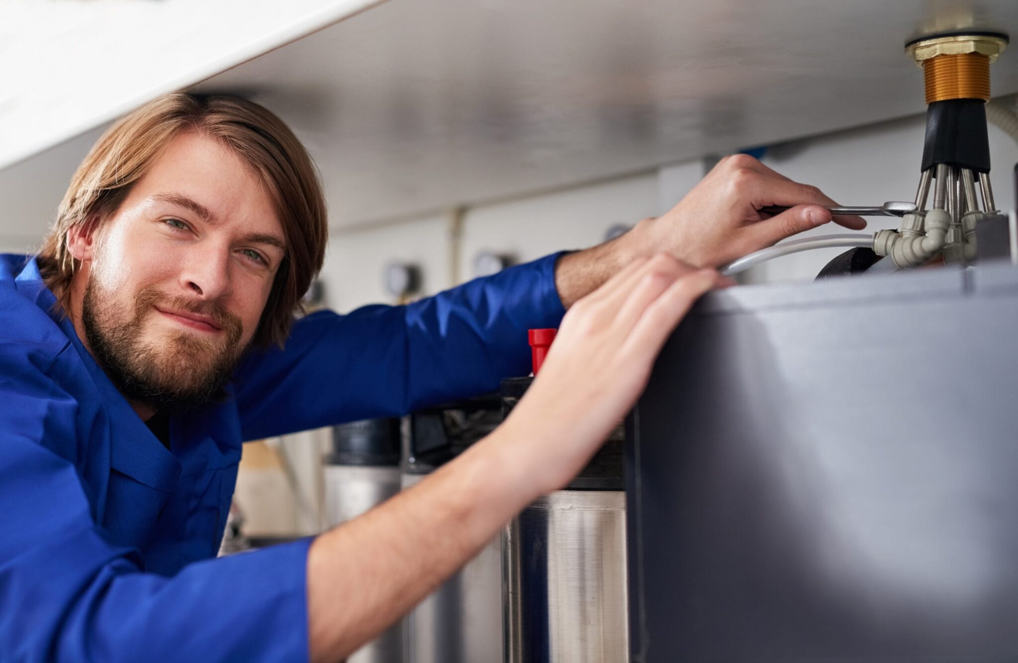 Technician servicing a residential water heater tank in Fort Collins