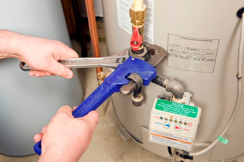 Plumber repairing a water heater valve in Fort Collins